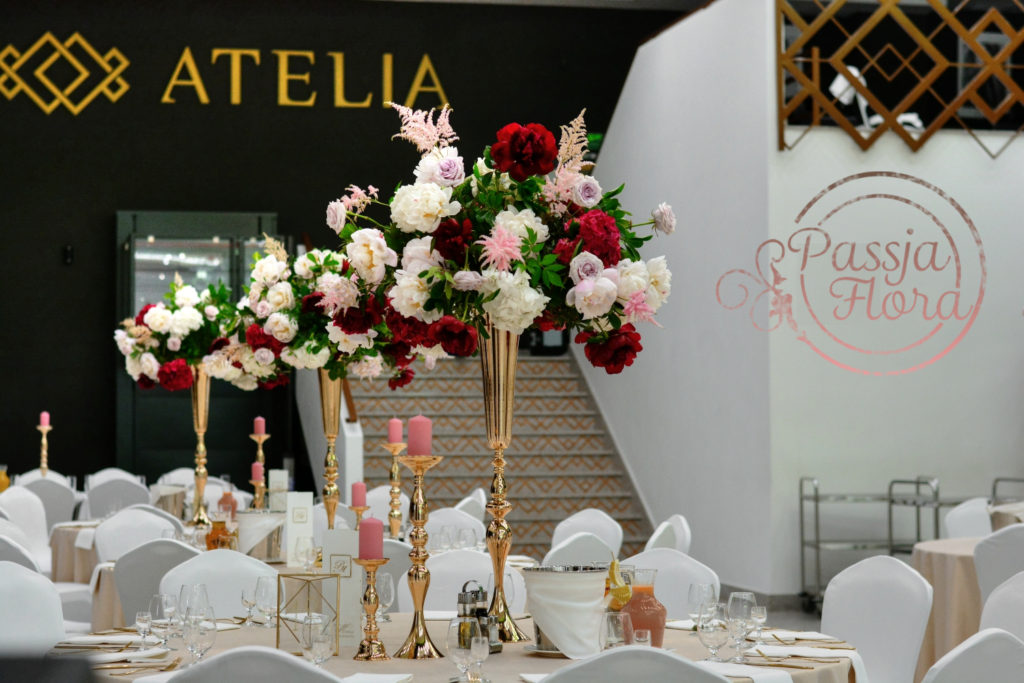 kwiatowe dekoracje na sali weselnej 