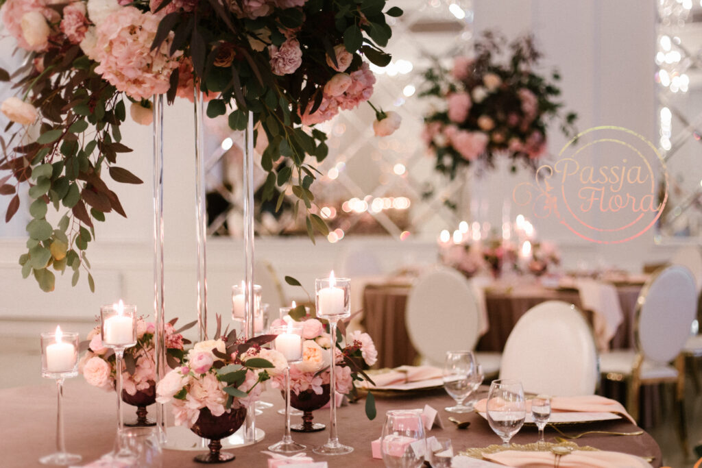 Kwiaty i świece na stołach gości